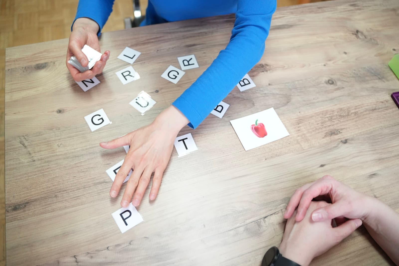 Logopädin bei einer Sprachübung mit einem Kind